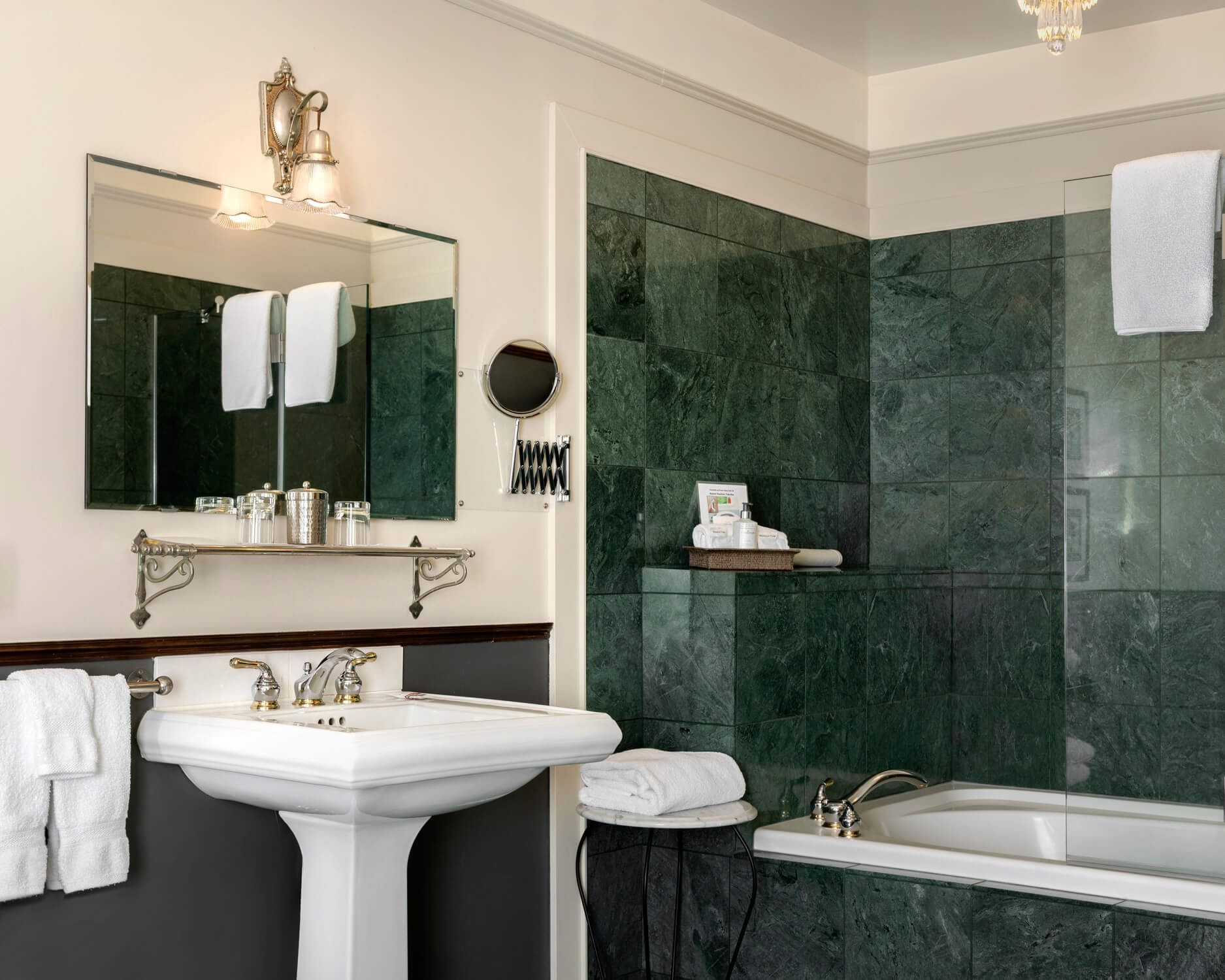 A bathroom with green tiles and a sink and bathtub