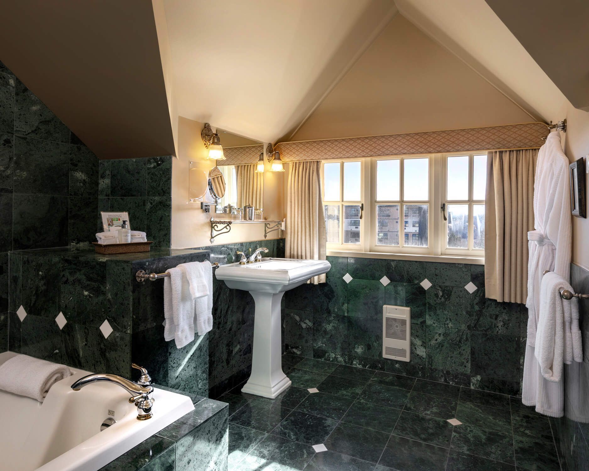 A bathroom with green tiles and a tub and sink