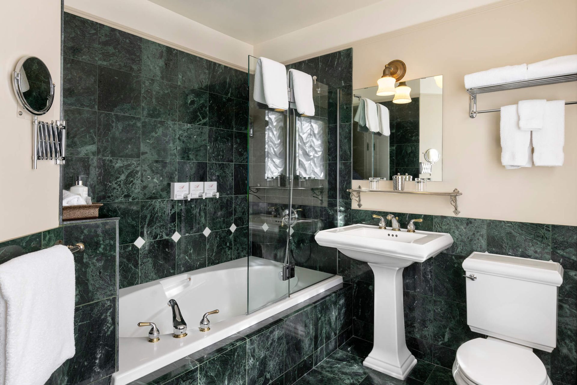 A bathroom with a tub , sink , toilet and mirror