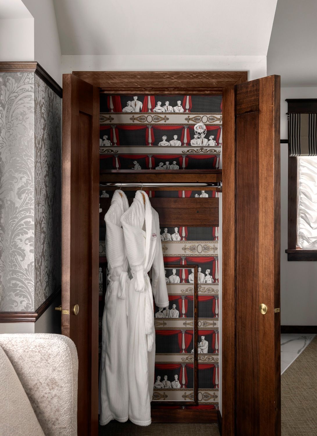 A white robe is hanging in a wooden closet