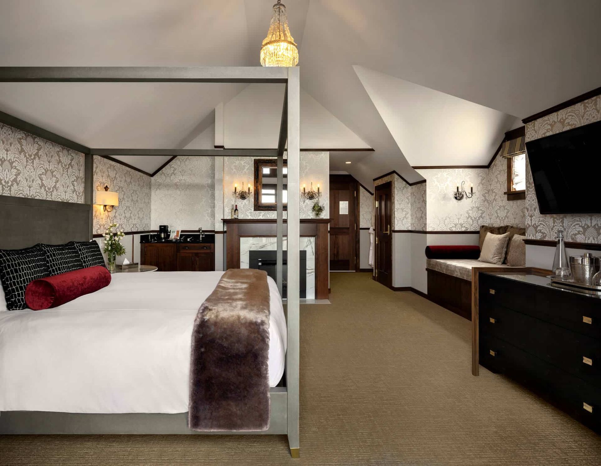 A hotel room with a four poster bed and a flat screen tv
