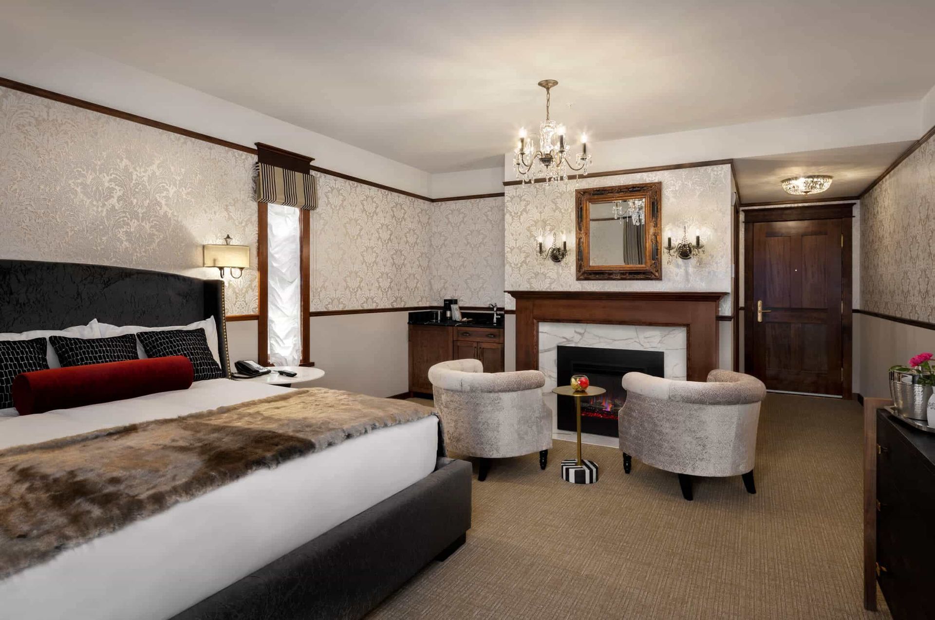 A hotel room with a king size bed and a fireplace