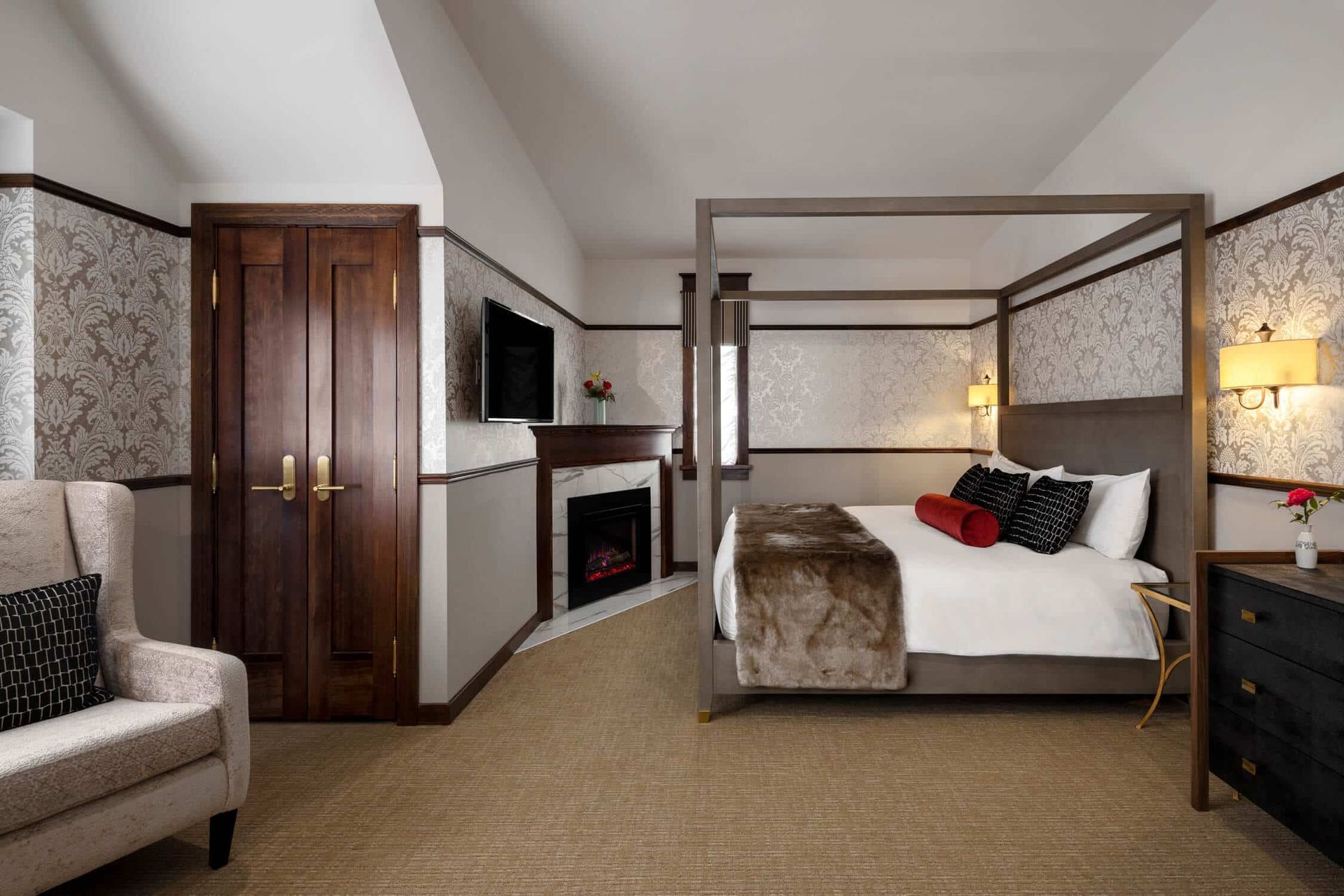 A hotel room with a four poster bed and a fireplace