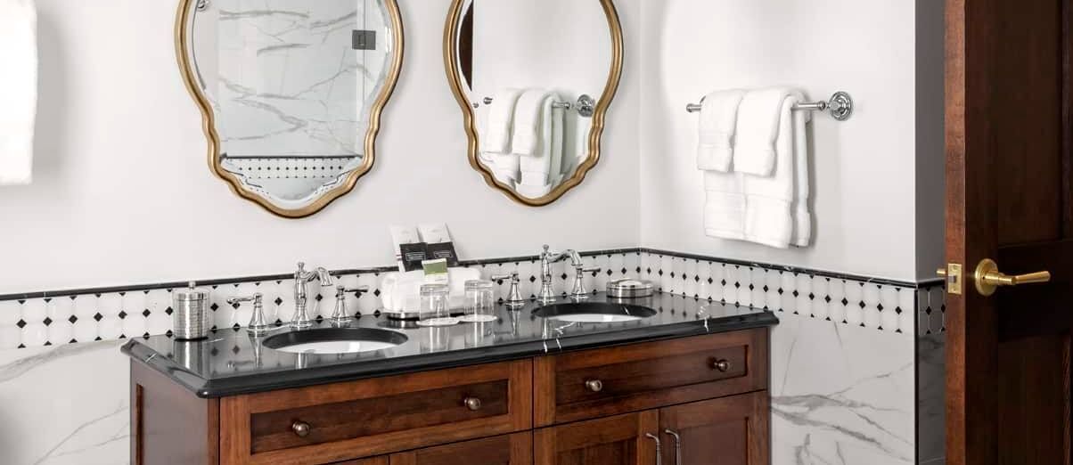 A bathroom with two sinks and two mirrors.