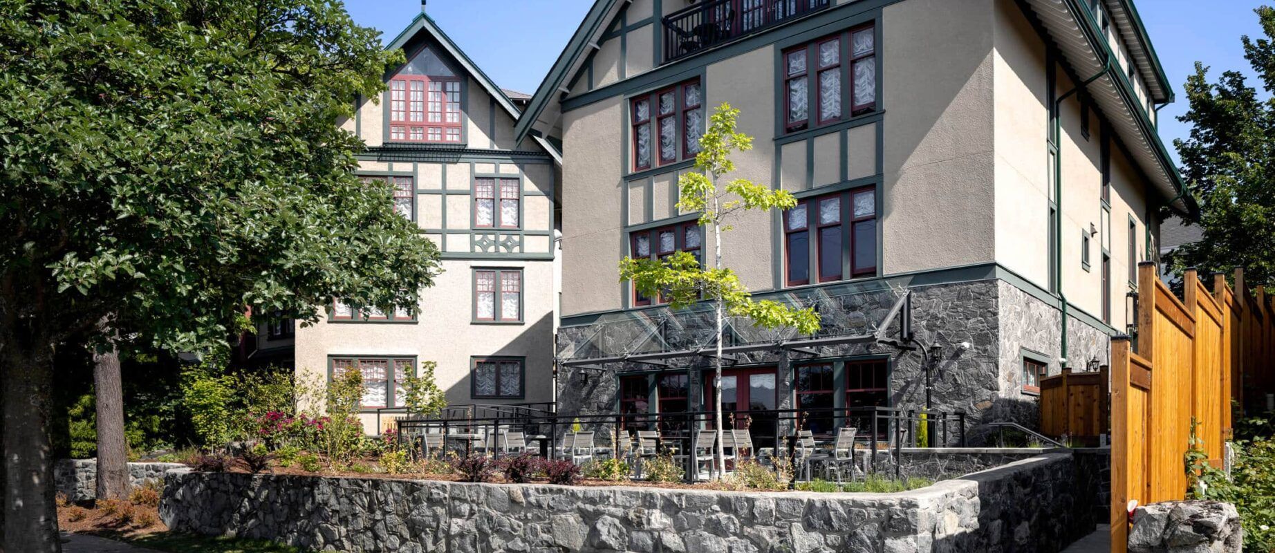 A large house with a stone wall in front of it