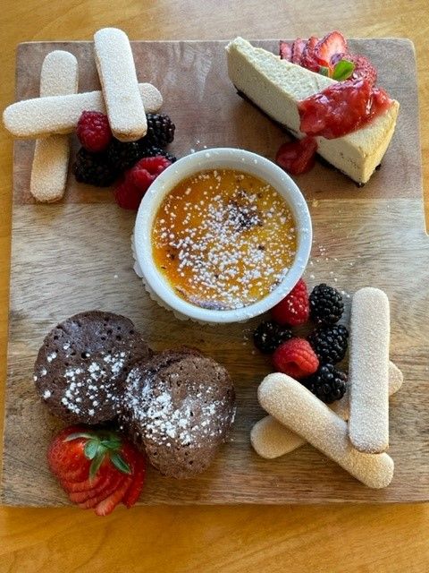 A wooden cutting board with a variety of desserts on it