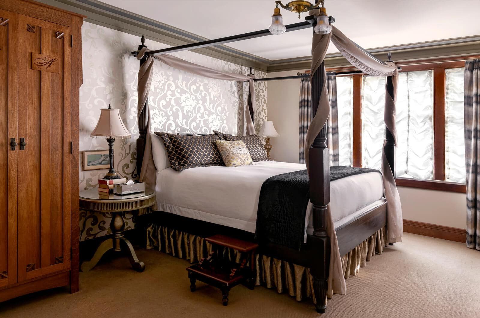 A bedroom with a four poster bed and a wardrobe