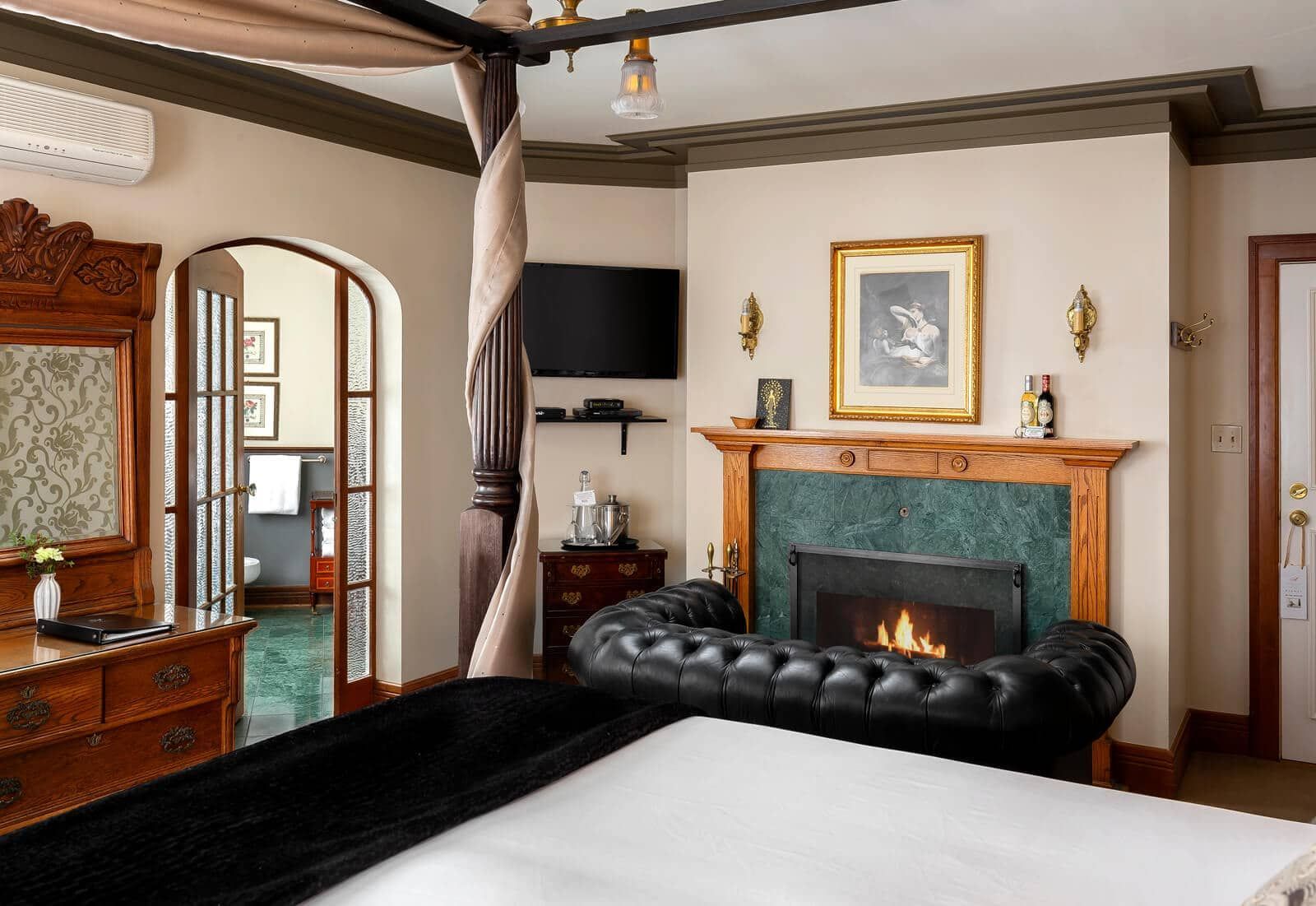 A bedroom with a fireplace and a canopy bed
