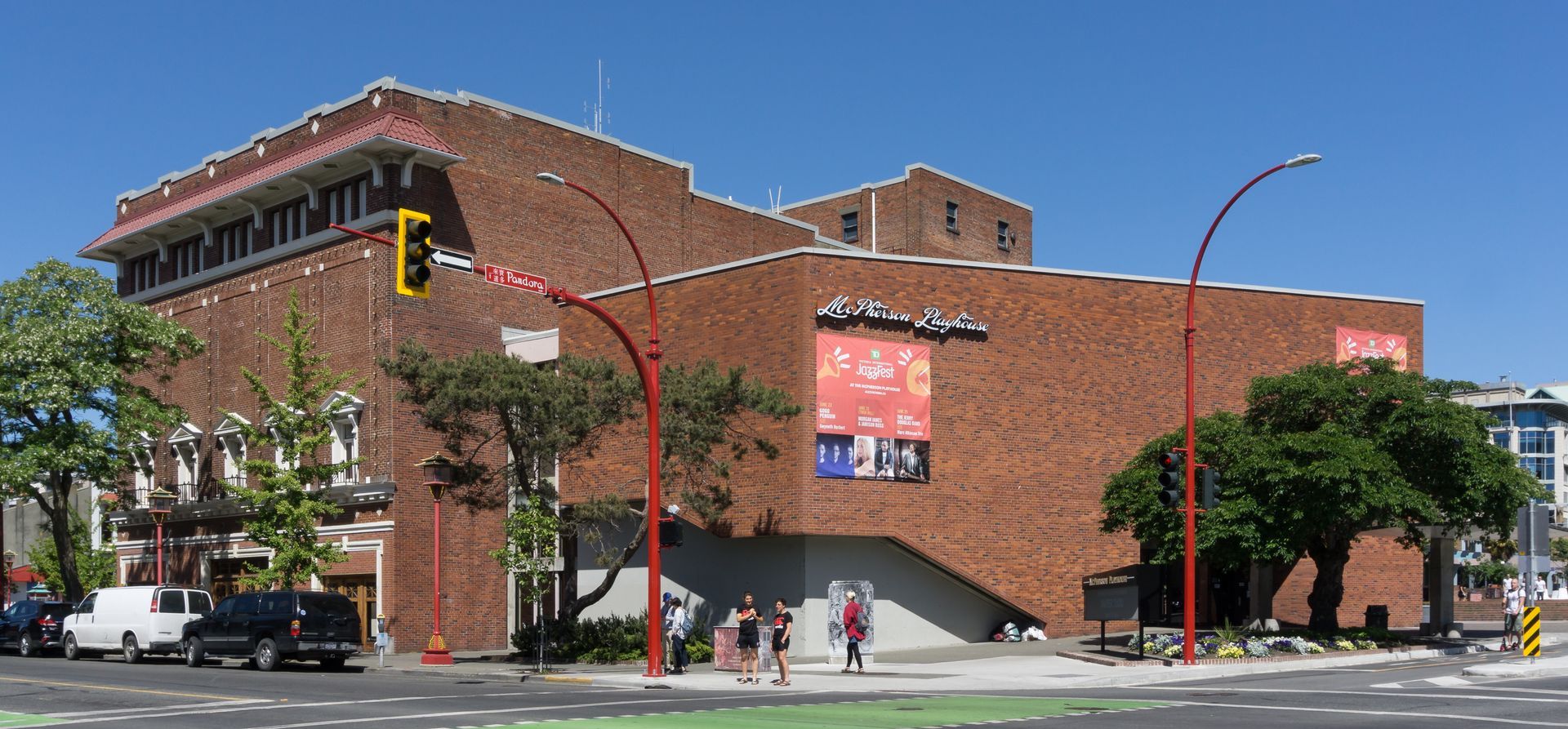 A large brick building is sitting on the corner of a city street.