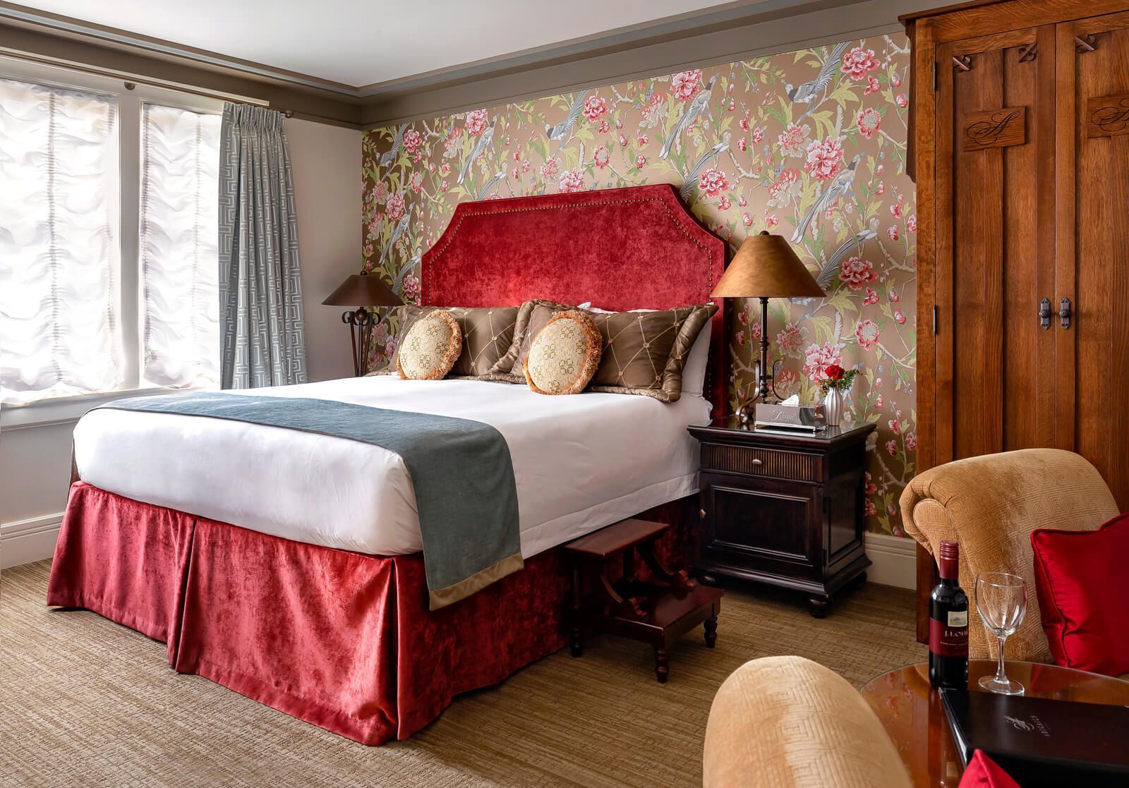 A hotel room with a large bed and a chair