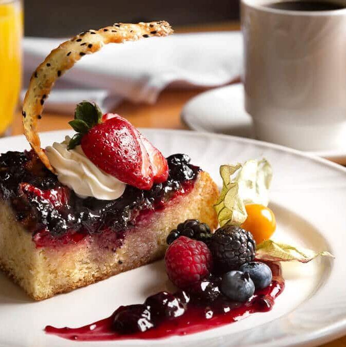 Sweet breakfast with berries and whipped cream on a white plate
