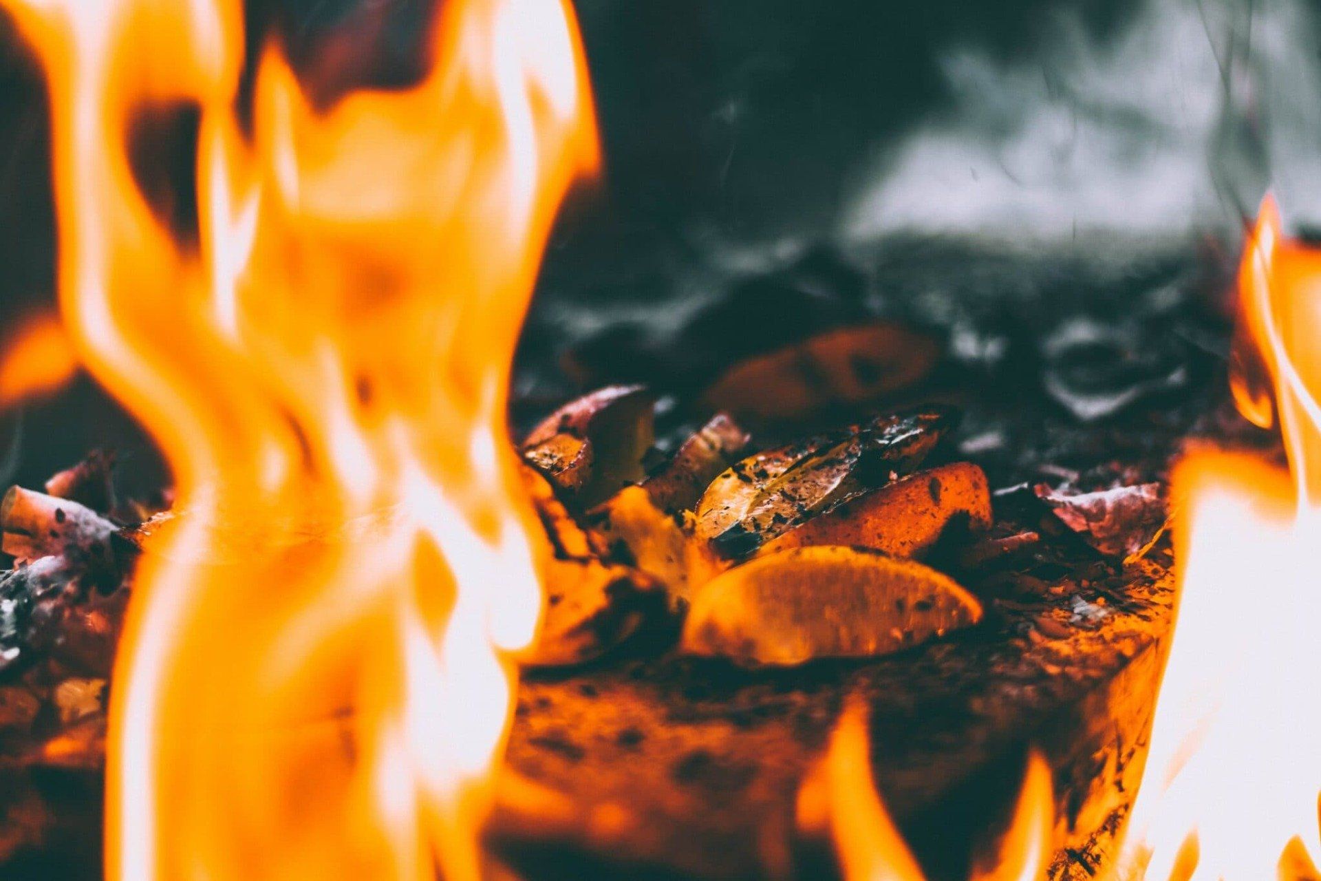 Closeup of yellow flames and food on grill