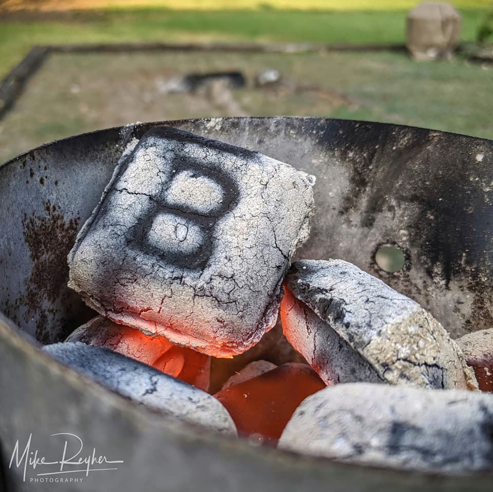Closeup photo of a B&B charcoal briquet burning in a charcoal chimney
