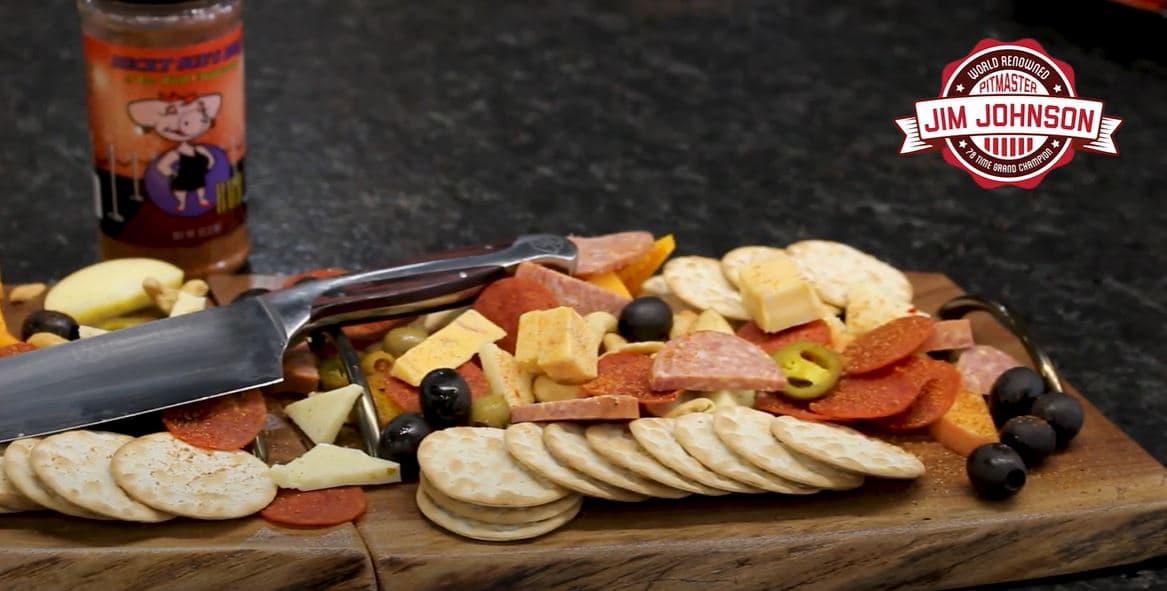 charcuterie board of cheese and crackers wit BBQ Pitmaster Jim Johnson logo in upper right