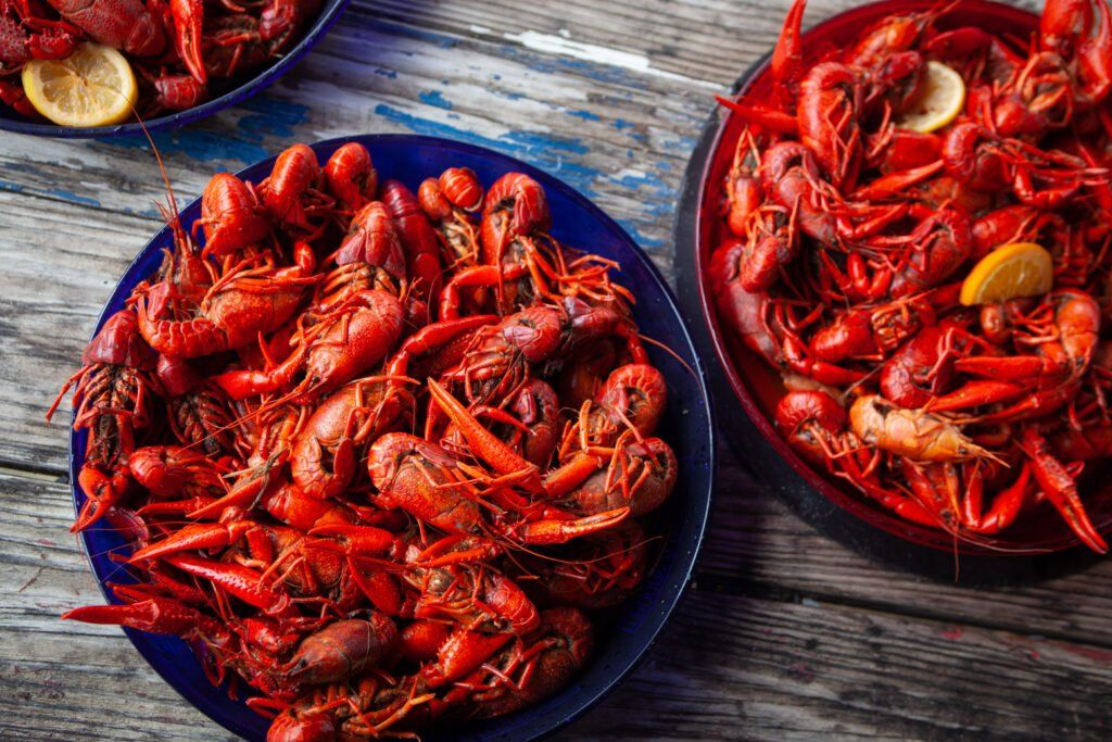 plates filled with red, cooked crawfish garnished with lemon