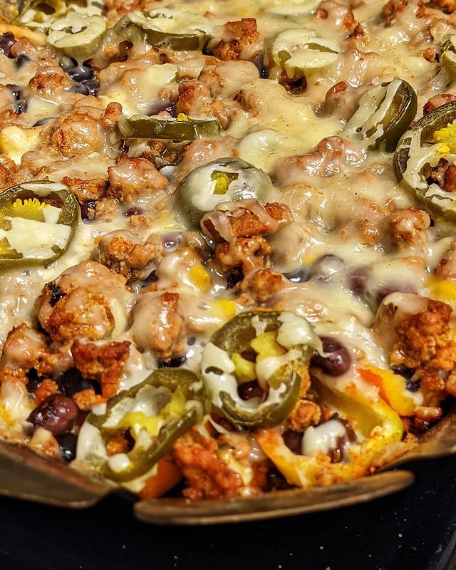 Nachos with melted cheese and jalapenos in a pan