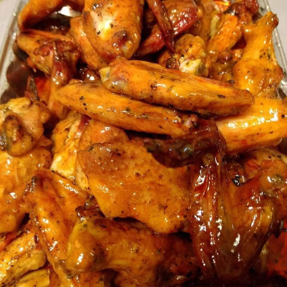 Bird's eye view of seasoned, grilled chicken wings piled high on a plate