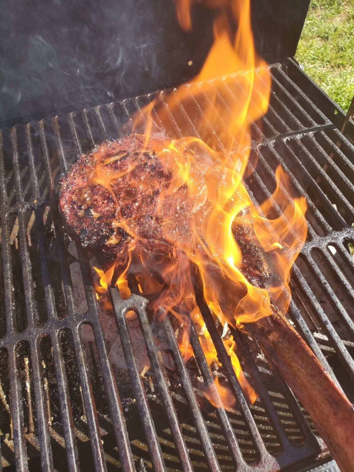 Tomahawk steak with flames on the grill