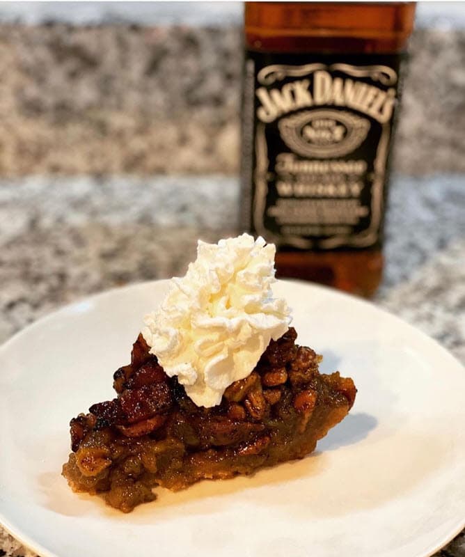 Slice of Whiskey Maple Bacon Pie with whipped cream