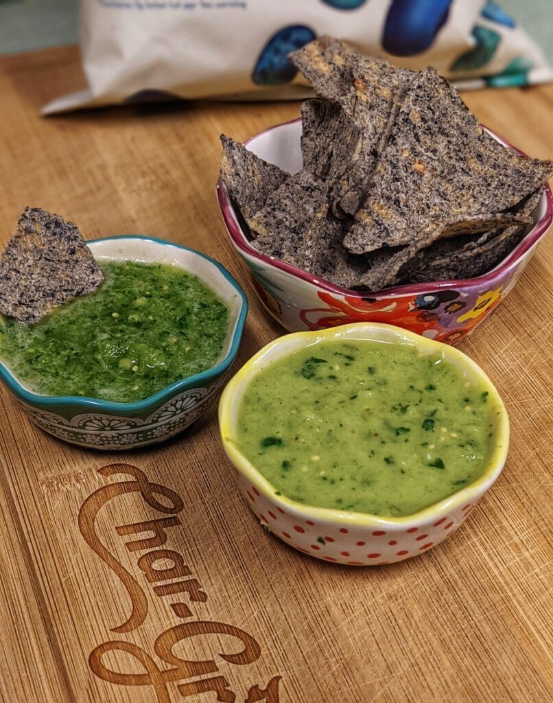 Bowls of black bean chips, salsa verde, and creamy avocado sauce