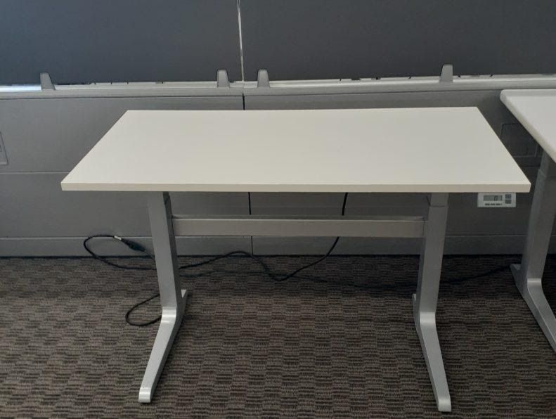 A white desk is sitting on a carpeted floor