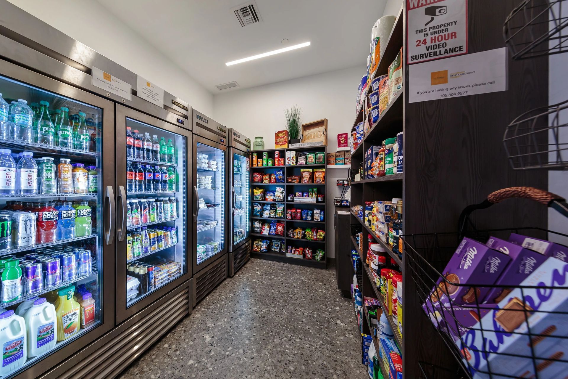 A small convenience store with refrigerators of drinks and shelves of snacks.