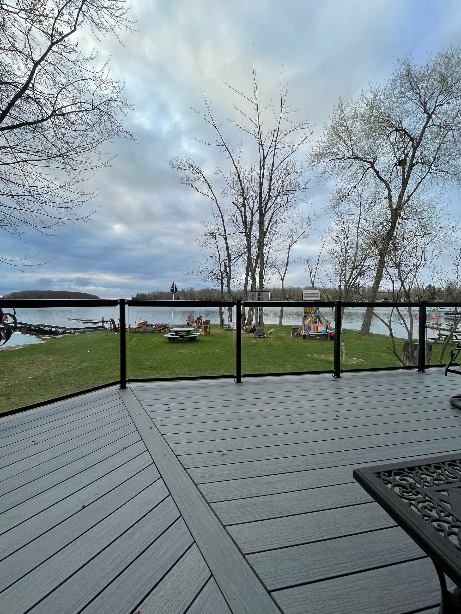 A deck with a view of a lake and trees.