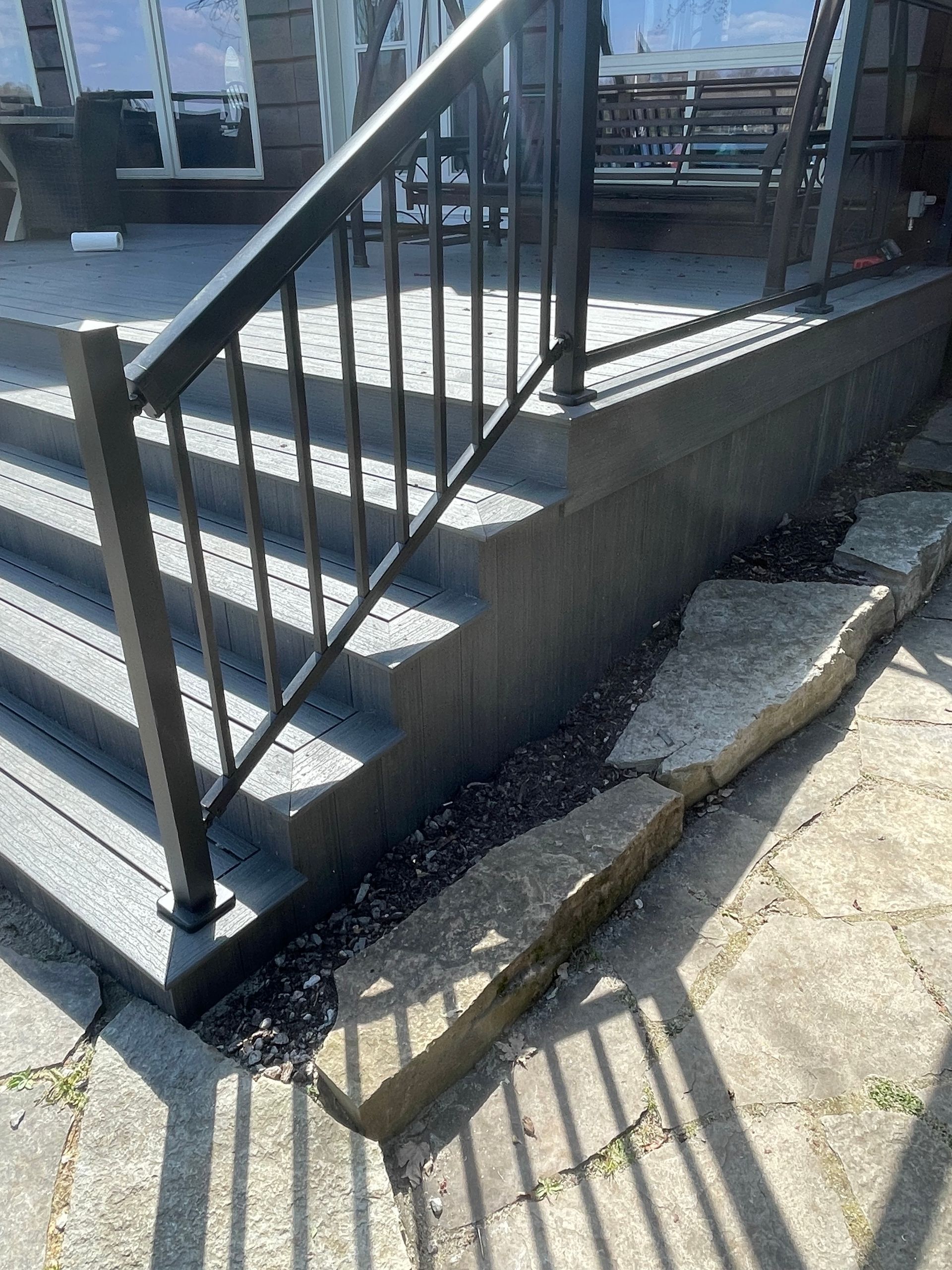 A set of stairs with a metal railing on the side of a house.