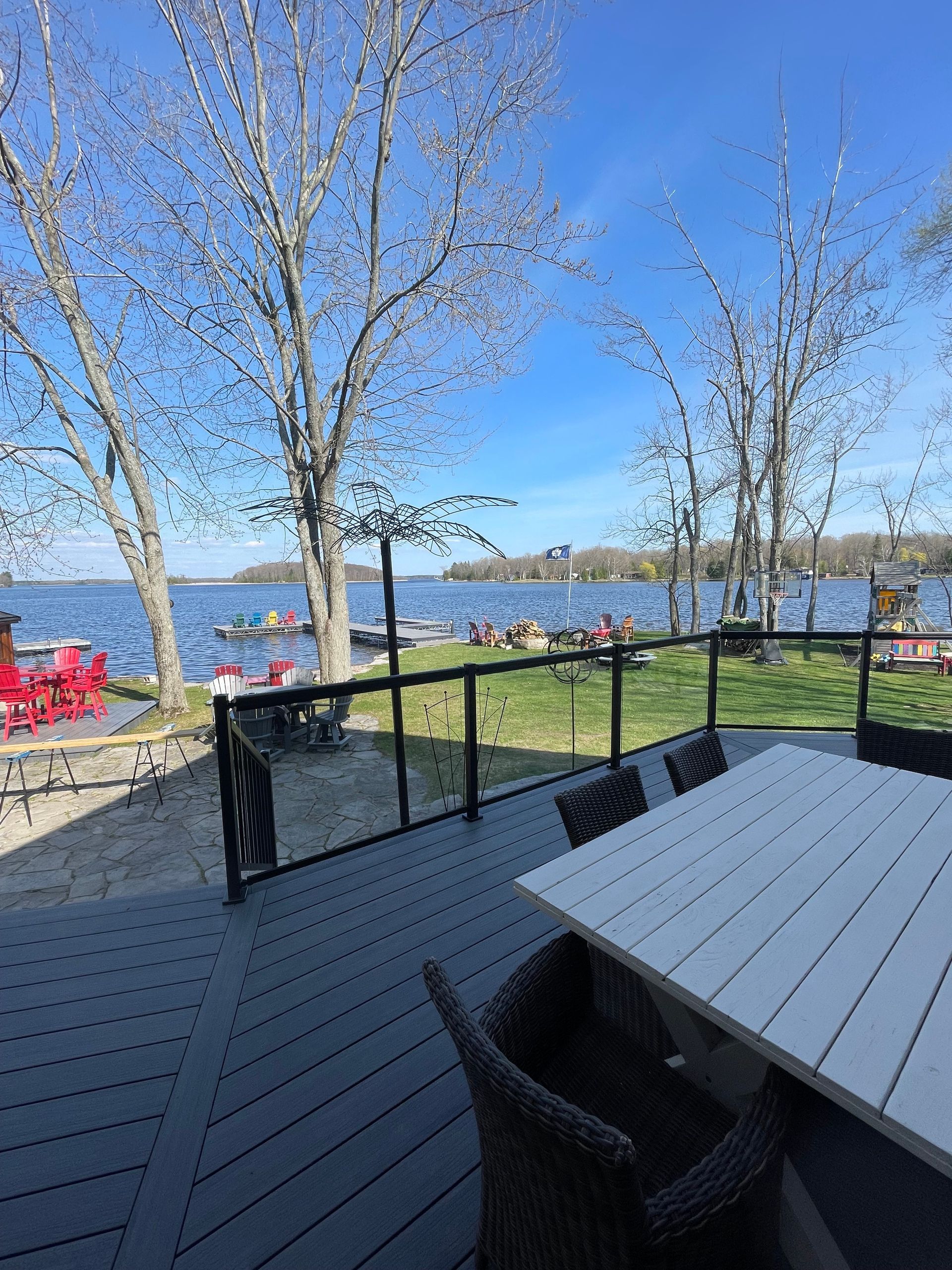 A deck with a table and chairs overlooking a lake.
