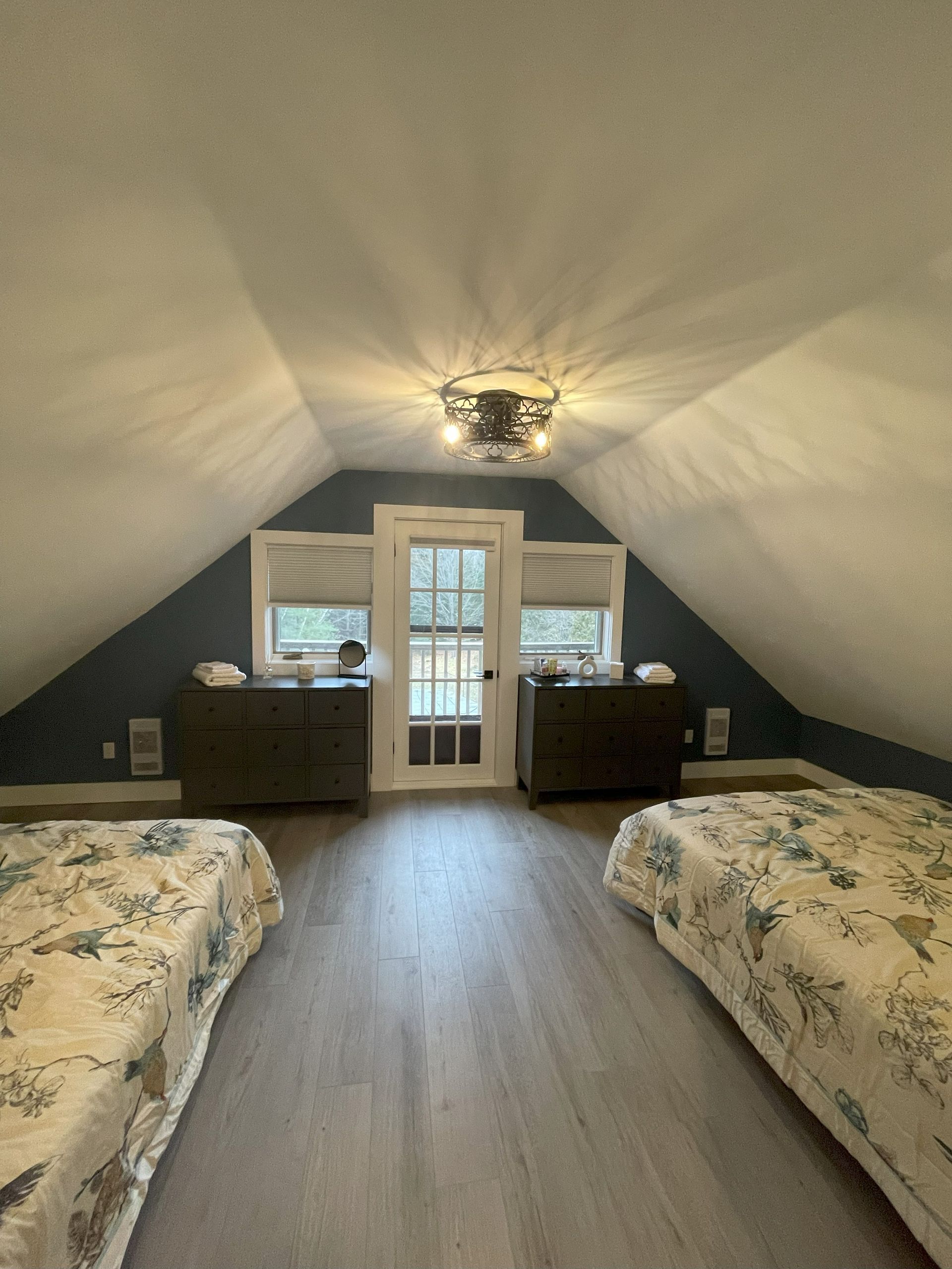 A bedroom with two beds and a ceiling fan