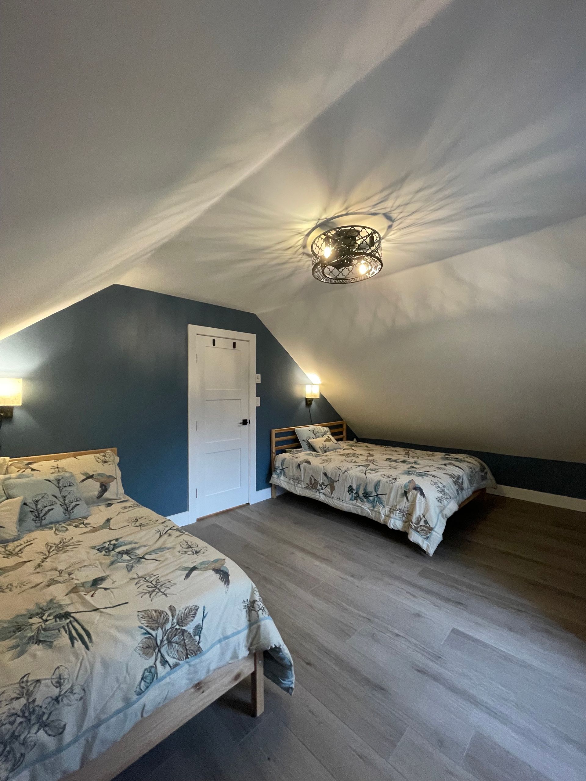A bedroom with two beds and a ceiling fan.