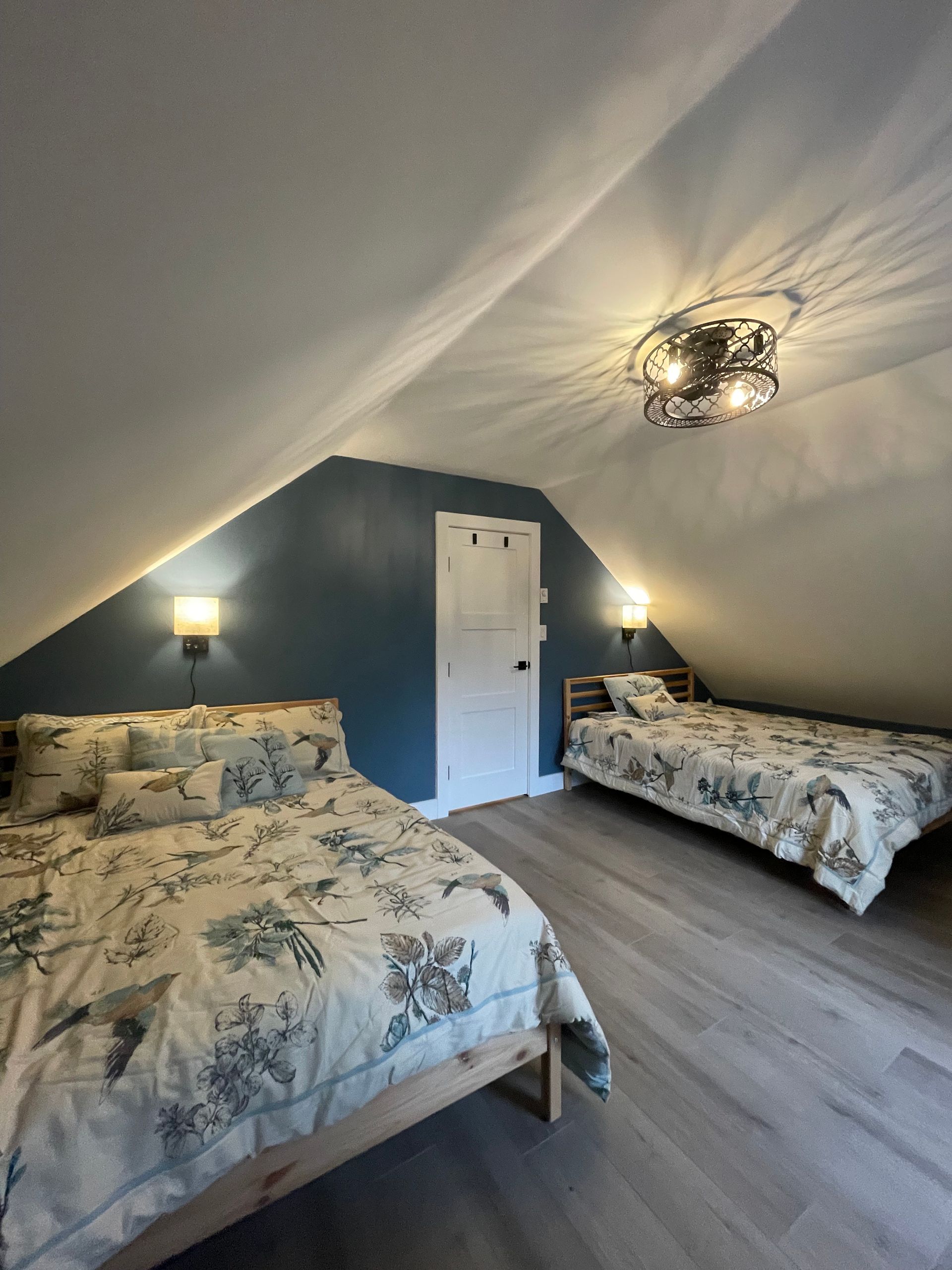 A bedroom with two beds and a ceiling fan.
