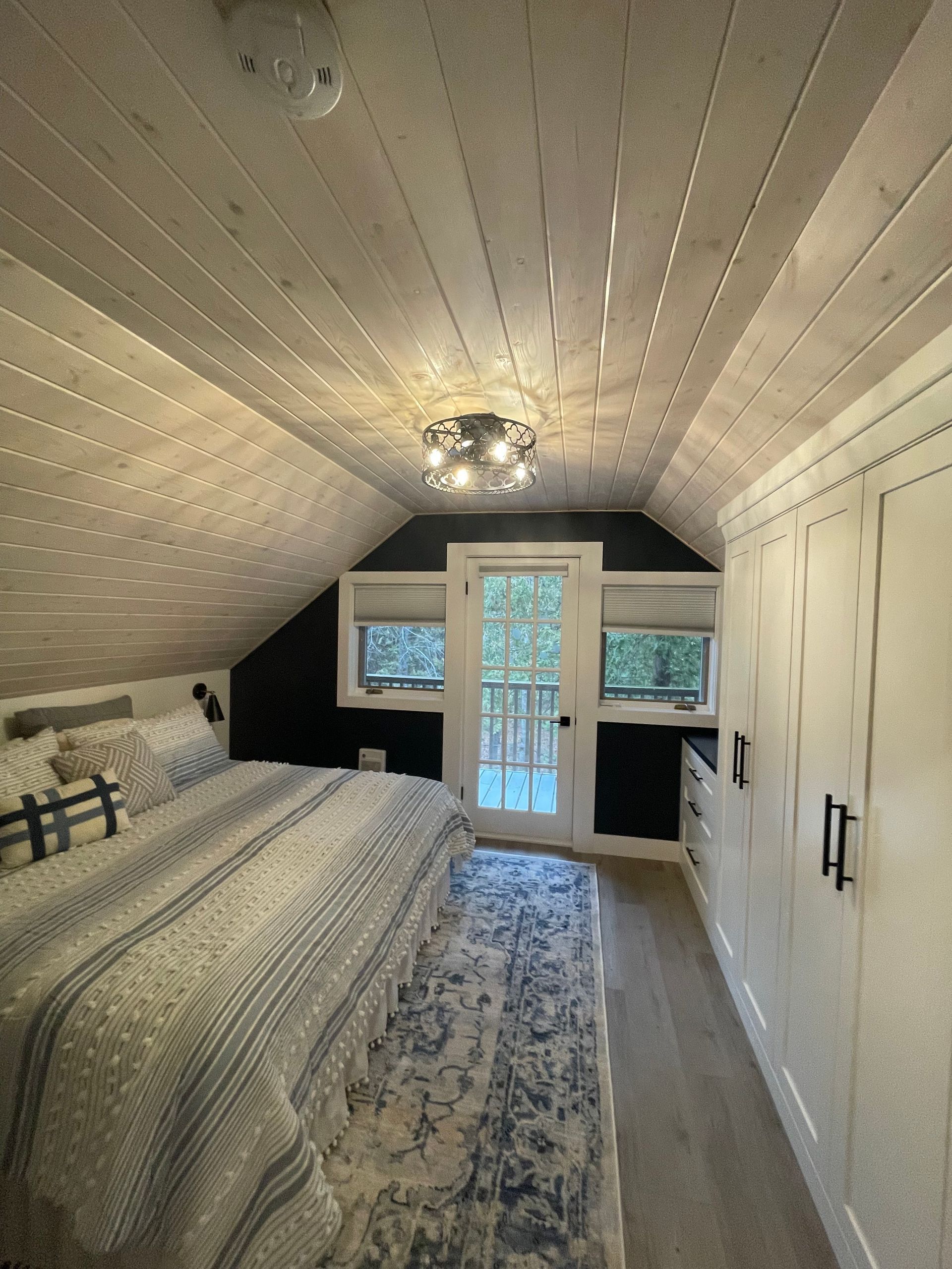 A bedroom with a large bed and a sliding glass door.