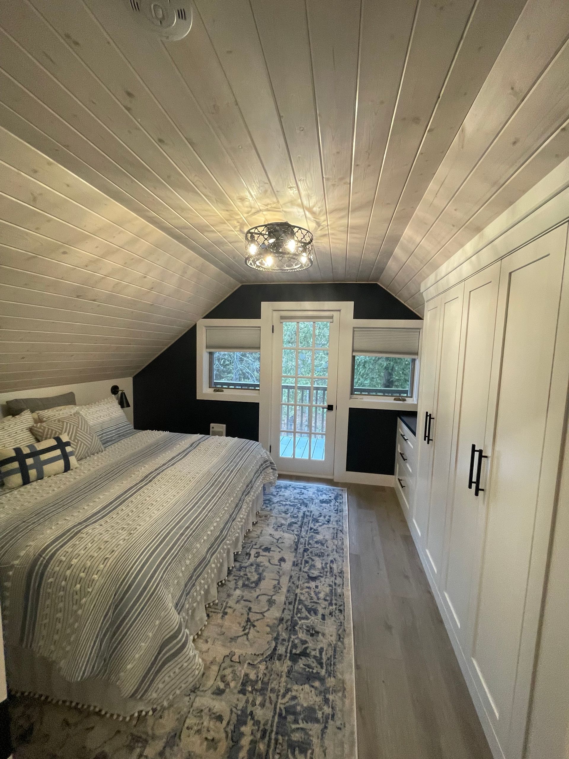 A bedroom with a bed , closets , and a window.