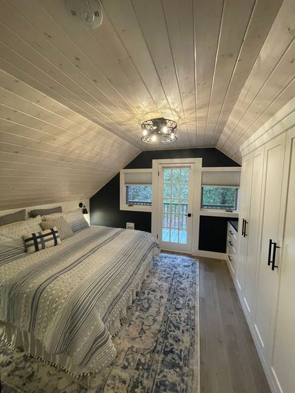 A bedroom with a large bed and a sliding glass door.