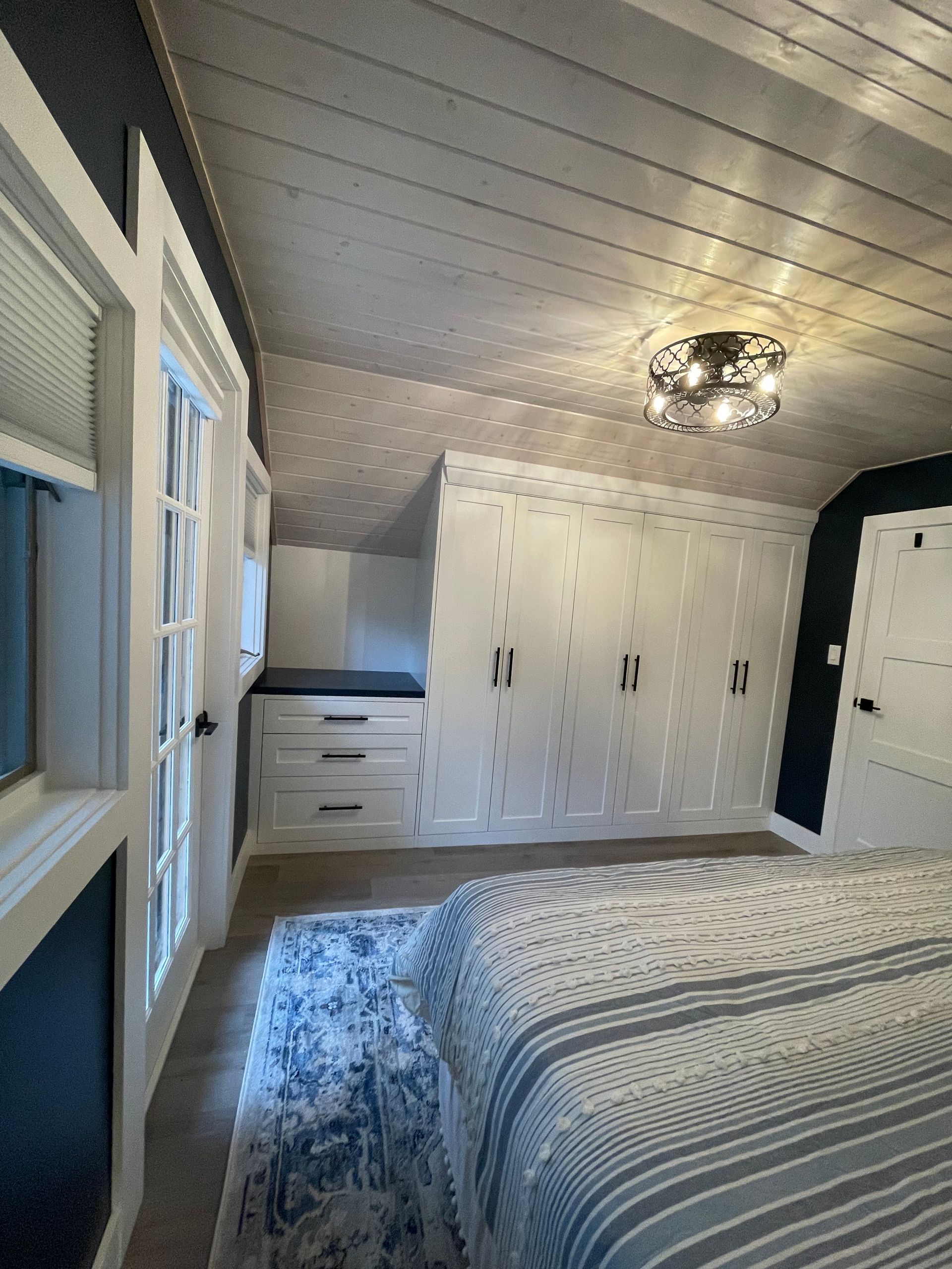 A bedroom with a bed , closets , and a rug.