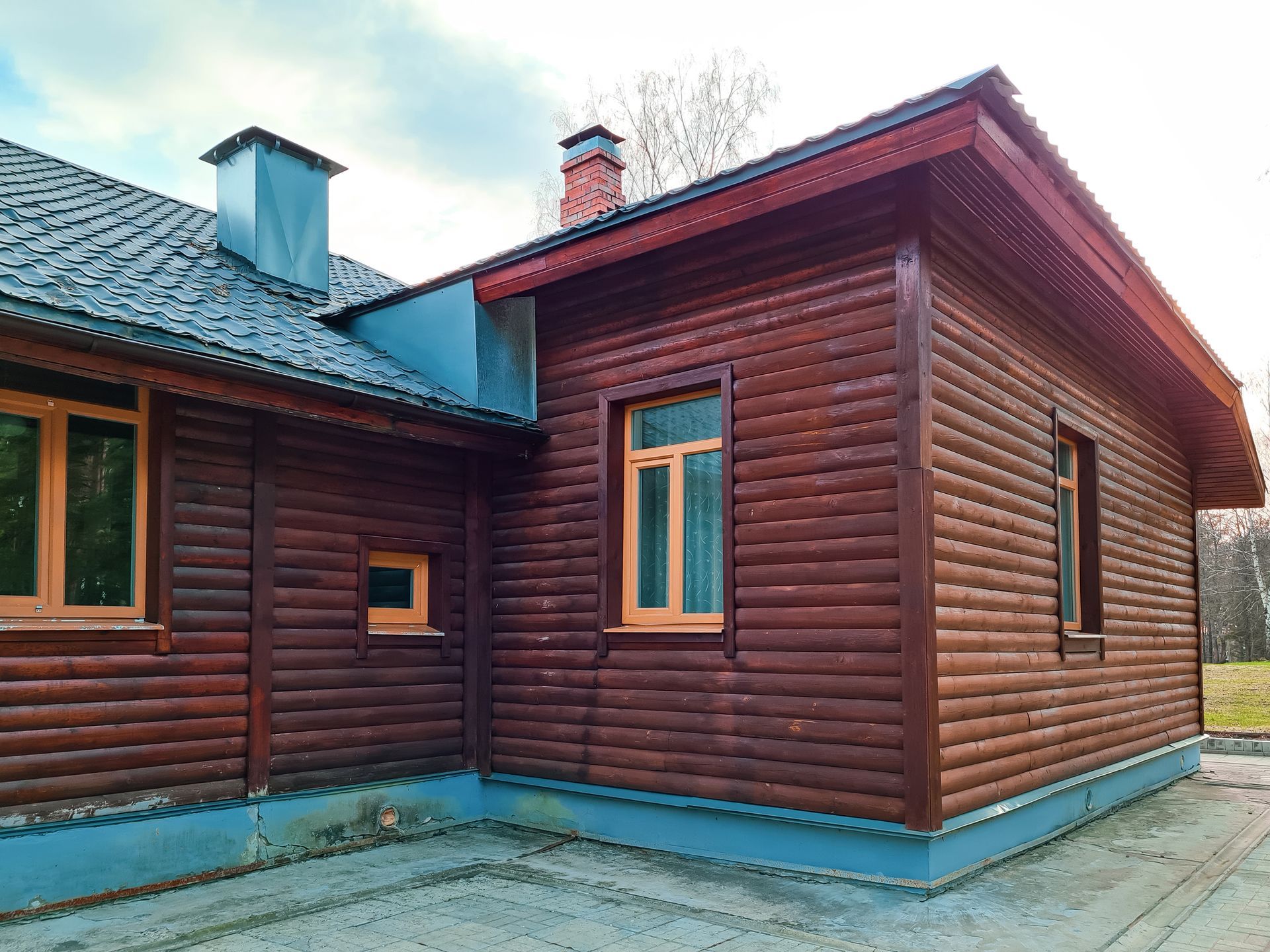 A wooden house with a lot of windows and a chimney.