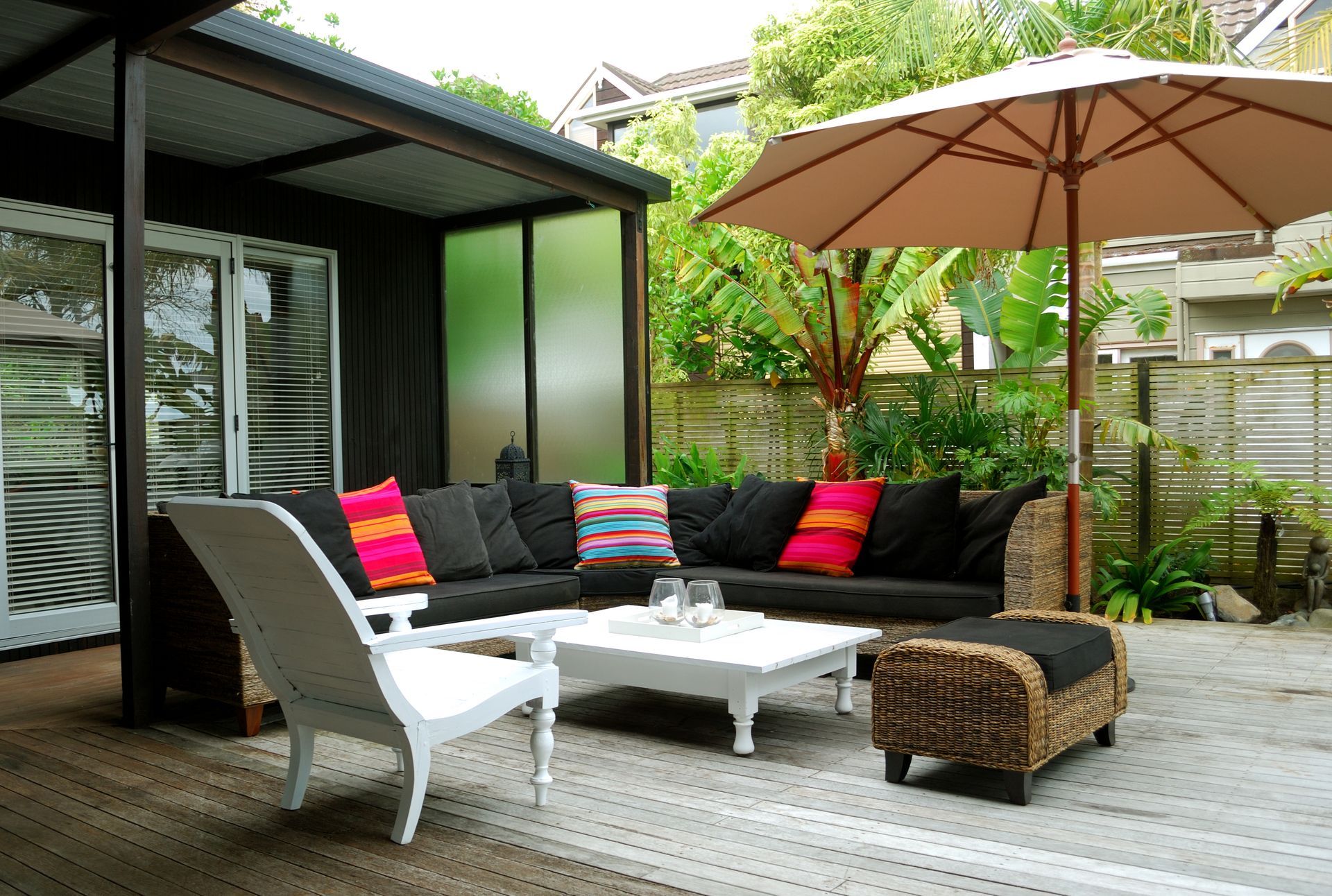 A patio with a couch and chairs under an umbrella