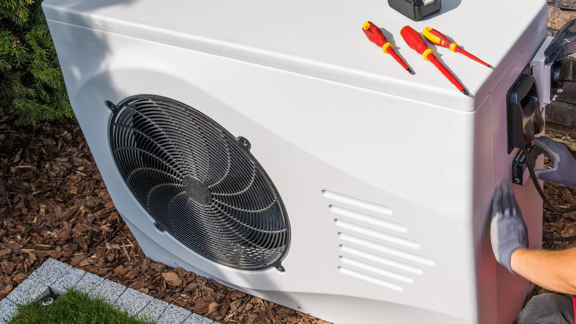 A row of air conditioners are sitting on the side of a building.