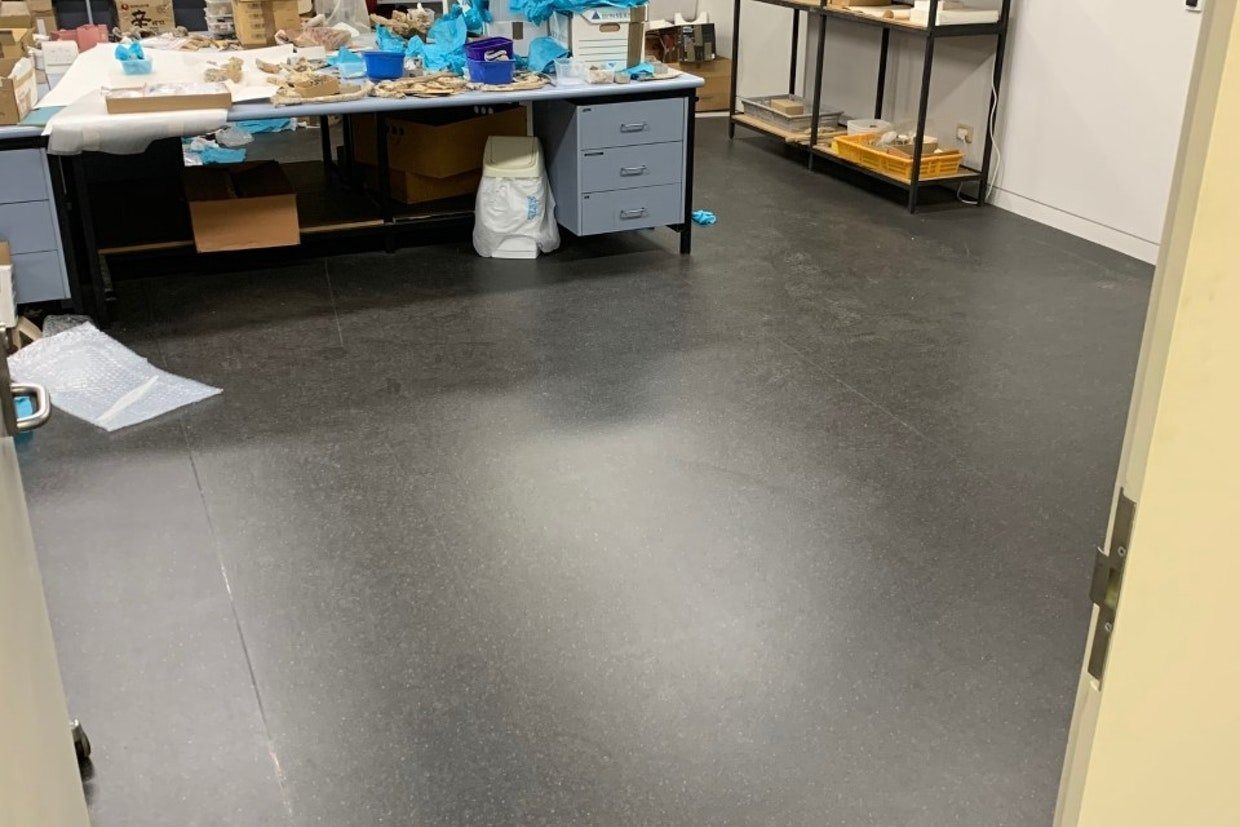 View of a workspace with dark gray flooring and a cluttered desk. — Ozwide Flooring In Ciccone, NT