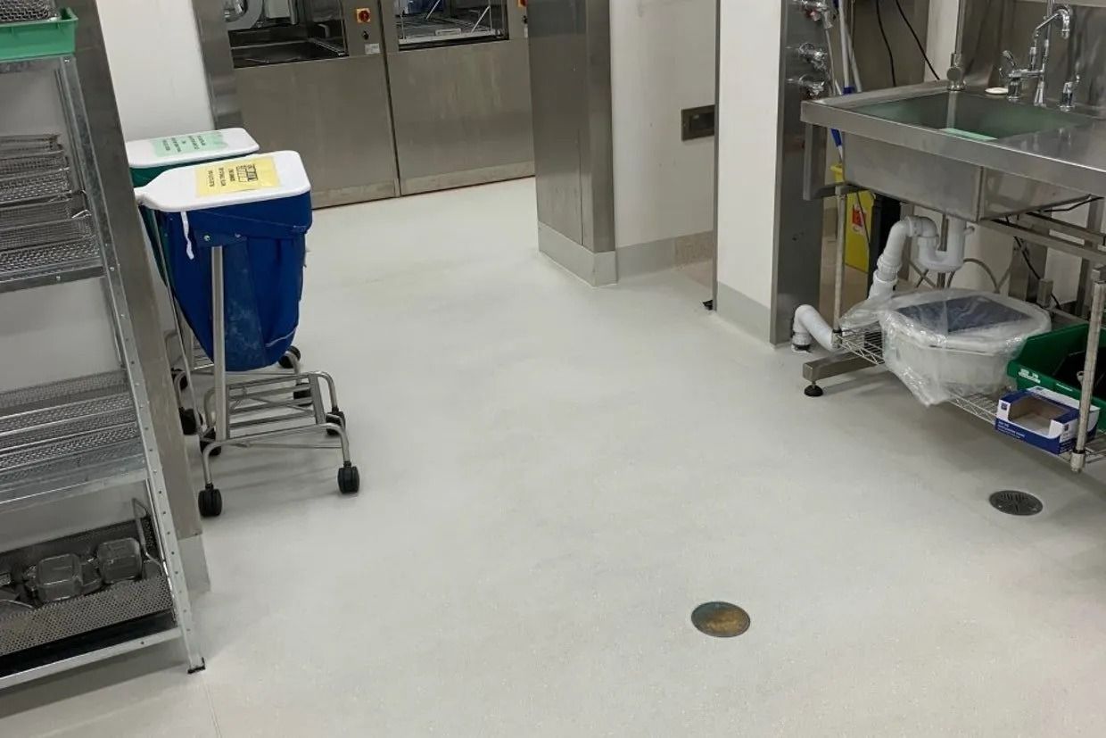 A Sterile Room With Stainless Steel Equipment, Blue Trash Can, and a Sink — Ozwide Flooring In Ciccone, NT