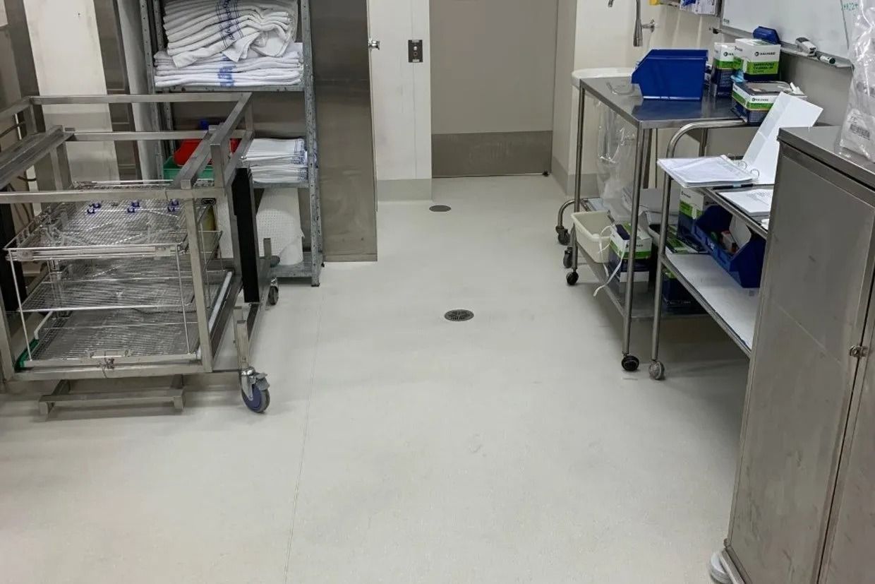 Sterile Medical Supply Room With Stainless Steel Carts, Shelves, and a White Floor — Ozwide Flooring In Ciccone, NT