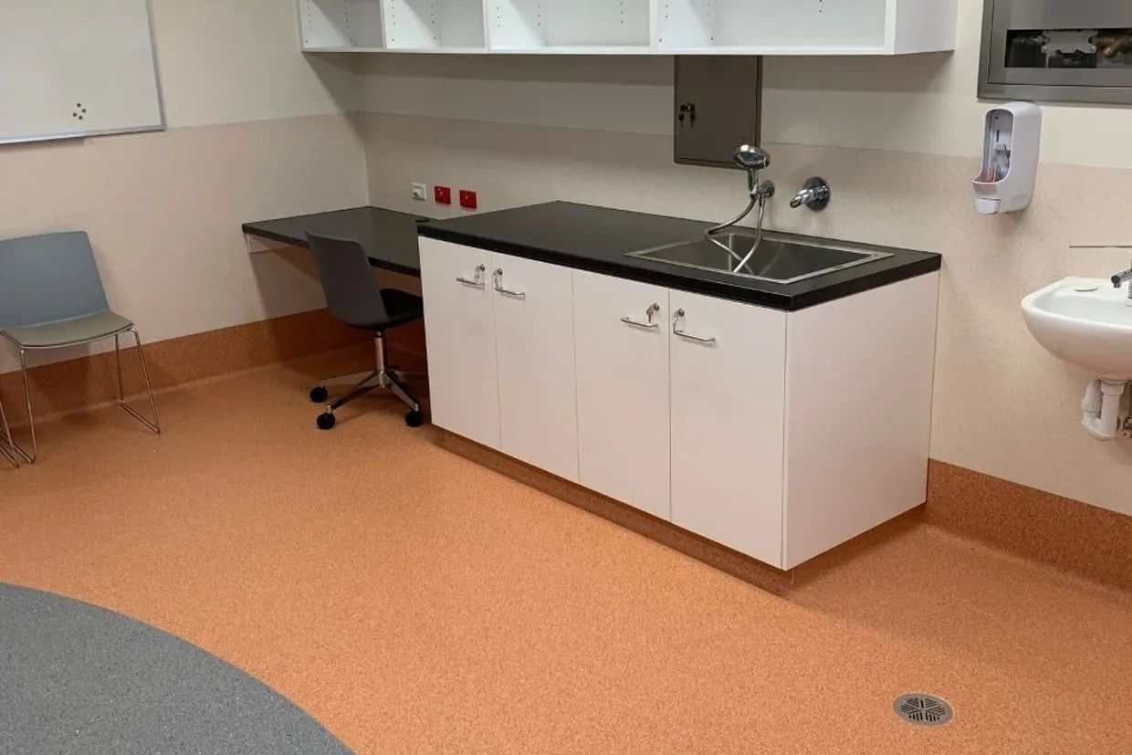 Examination Room With a Sink, Cabinets, and a Desk. Orange Flooring, White Walls — Ozwide Flooring In Ciccone, NT
