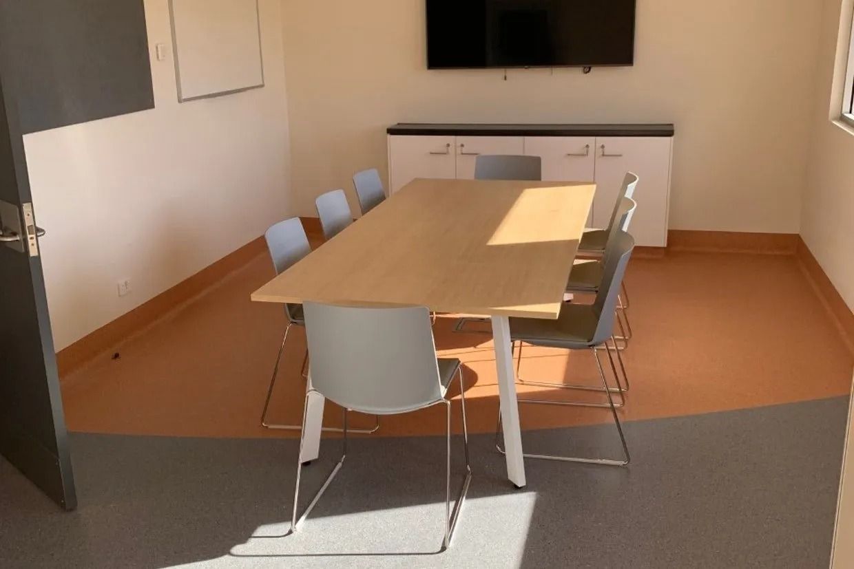 Conference Room With Table, Chairs, Tv, and Cabinets; Sunlight Through Window — Ozwide Flooring In Ciccone, NT