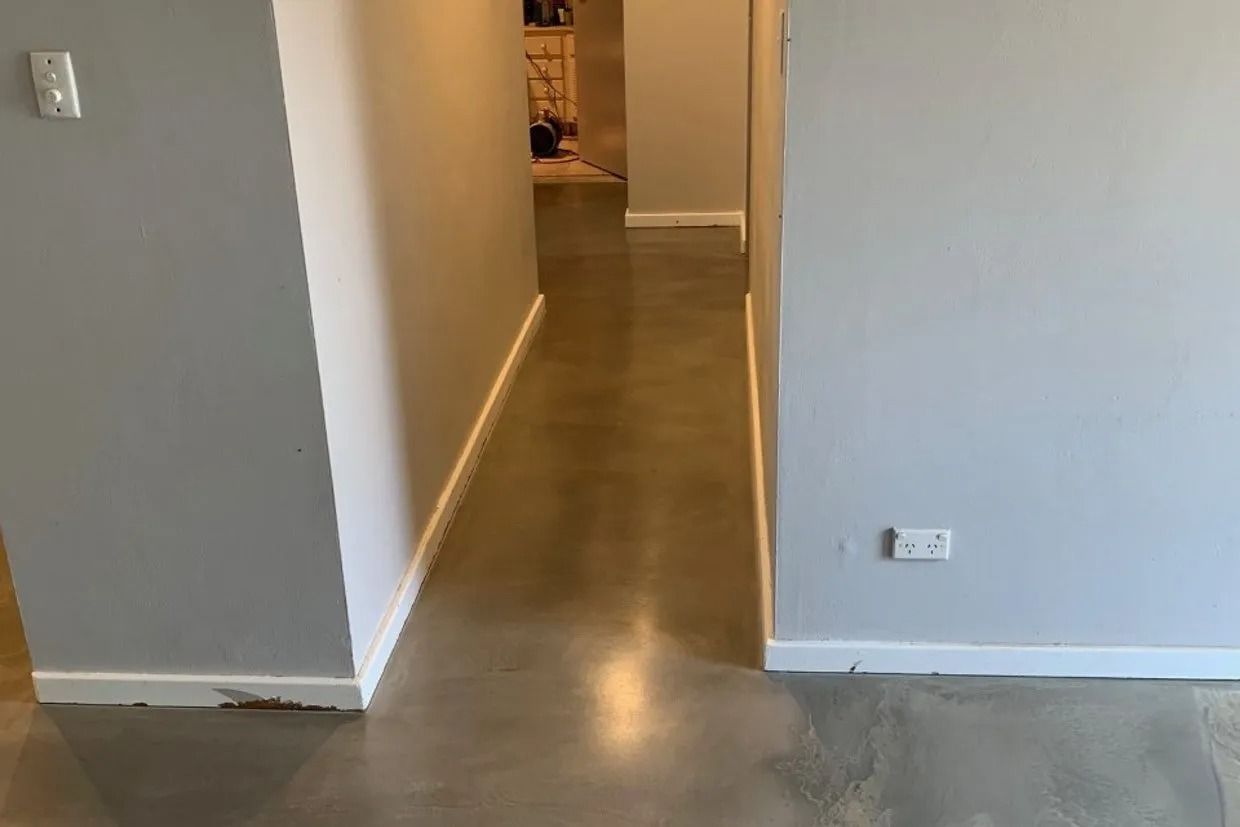 Hallway With Grey Walls, White Baseboards, and a Polished Concrete Floor — Ozwide Flooring In Ciccone, NT