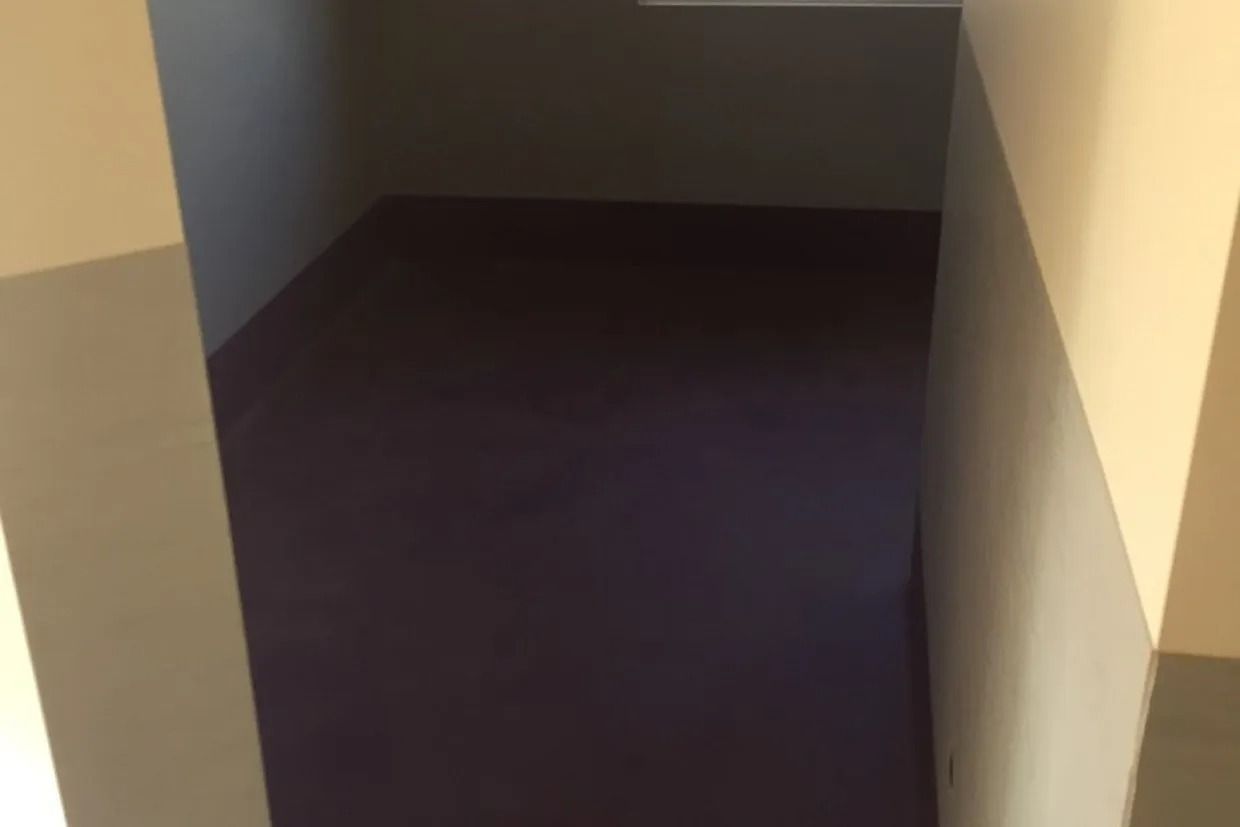 A Dark, Empty Alcove With Purple Flooring and White Walls — Ozwide Flooring In Ciccone, NT