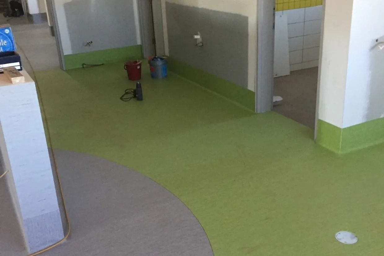 Green and Beige Flooring in a Hallway; Walls Are Grey and White — Ozwide Flooring In Ciccone, NT