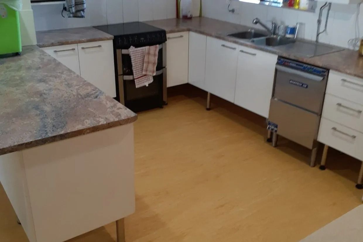 Kitchen With White Cabinets and Speckled Countertops — Ozwide Flooring In Ciccone, NT