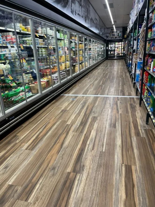 A Grocery Store Aisle With Refrigerator Cases on the Left and Shelves on the Right — Ozwide Flooring In Ciccone, NT