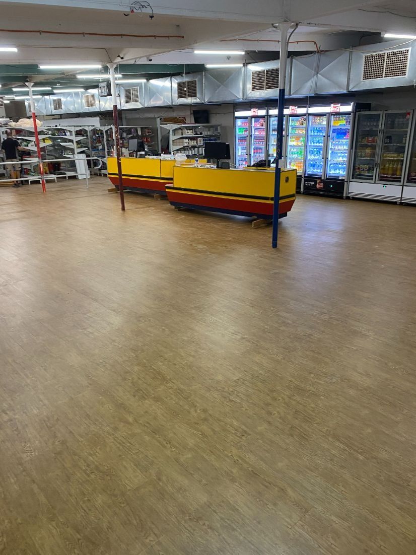 An Empty Store Interior With a Yellow and Red Counter — Ozwide Flooring In Ciccone, NT
